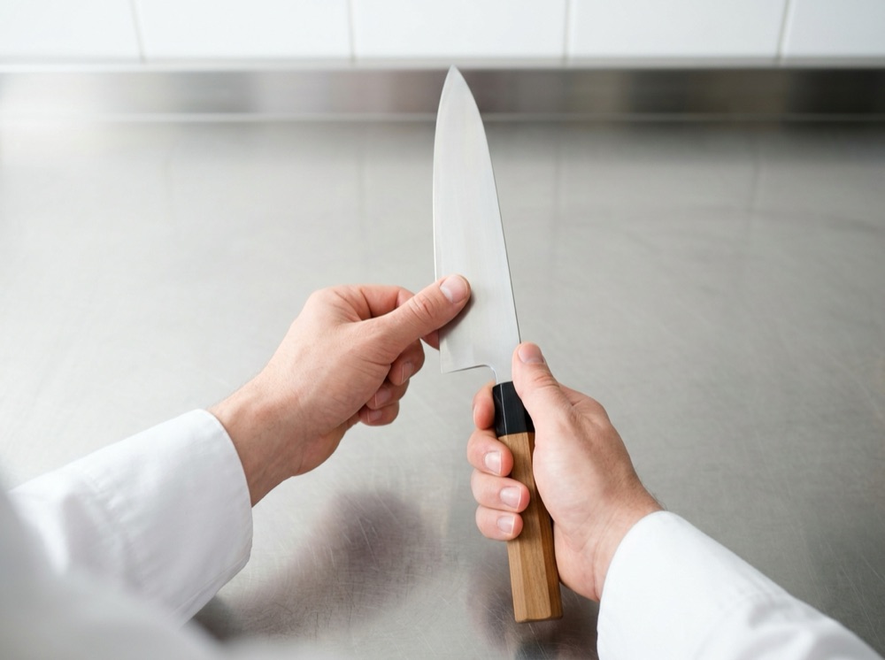 返りの確かめ方。親指の腹を峰側から刃先へ、刃と直角にそっとすべらせ、刃先で引っかかるかを指で感じる